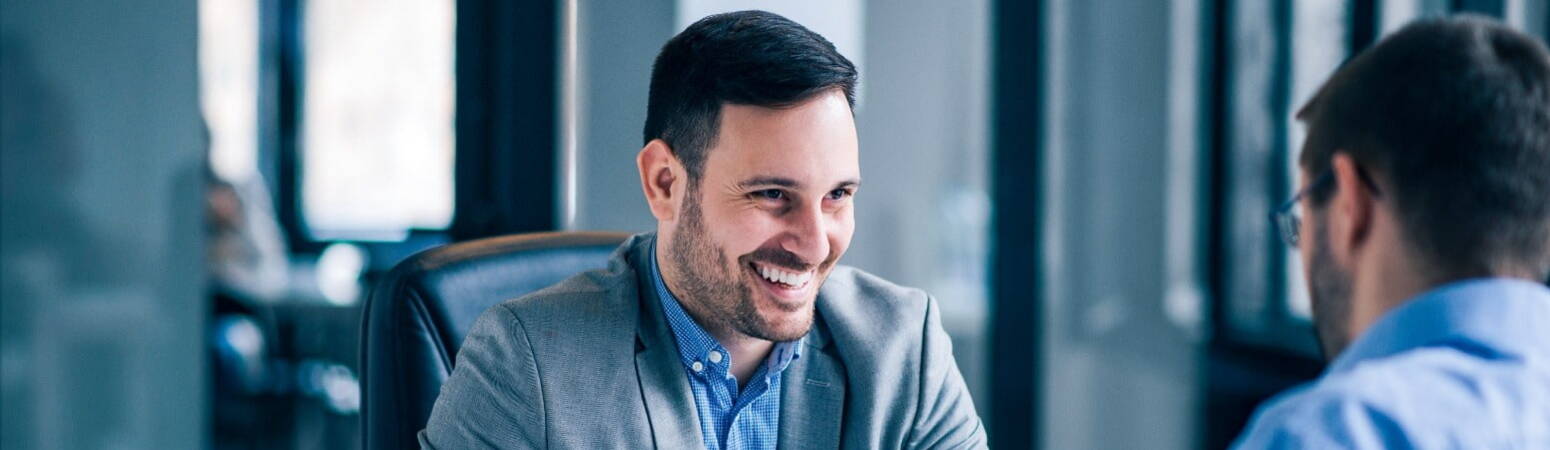 A lawyer smiling whilst he signs a contract