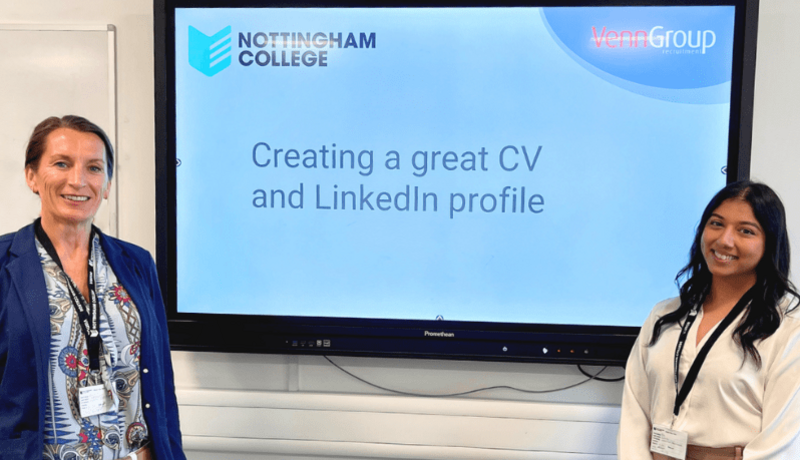 Two female recruiters standing in front of a screen leading an employability seminar.