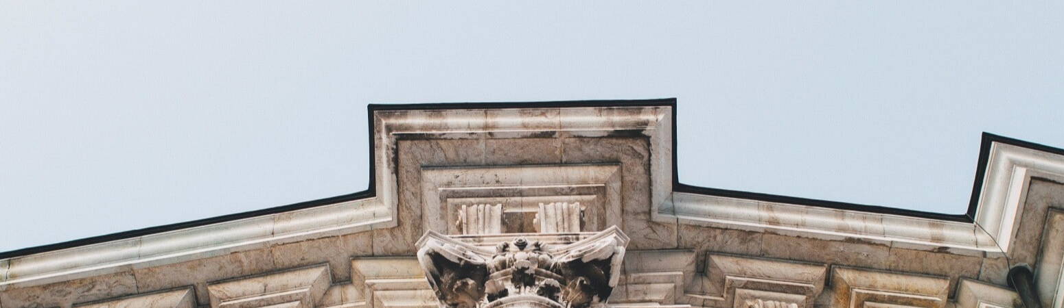 Looking up the white wall of a grand legal establishment